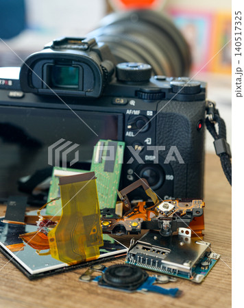 Mirrorless camera after repair with replaced electronic parts displayed in foreground on workbench Mirrorless camera after repair with replaced electronic parts displayed in foreground on workbench 140517325
