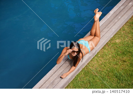 Woman, aerial or tanning at swimming pool to relax, rest or chill in summer holiday vacation in Hawaii. Calm girl, break and zen female person sunbathing in a spa at resort, home or hotel for peace Woman, aerial or tanning at swimming pool to relax, rest or chill in summer holiday vacation in Hawaii. Calm girl, break and zen female person sunbathing in a spa at resort, home or hotel for peace 140517410