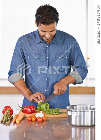 Cooking, man and cutting vegetables on kitchen counter for healthy diet, nutrition or lunch. Chopping board, food and vegan person preparing salad for dinner, meal and organic ingredients in home Cooking, man and cutting vegetables on kitchen counter for healthy diet, nutrition or lunch. Chopping board, food and vegan person preparing salad for dinner, meal and organic ingredients in home 140517437
