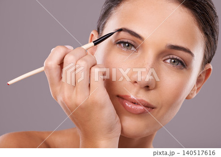 Woman, beauty and eyebrow brush with makeup, portrait and studio for glamour and radiance and lip gloss. Female person, blush and foundation in grey background, sexy and attractive confidence Woman, beauty and eyebrow brush with makeup, portrait and studio for glamour and radiance and lip gloss. Female person, blush and foundation in grey background, sexy and attractive confidence 140517616