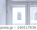 White window frames view of building located outside, simple lines. Window glass with dust. Light from day enters room softly. Details of interior, decorative for design 140517636