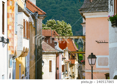 Colorful street in Krems, Austria with historic architecture and green hills 140517865