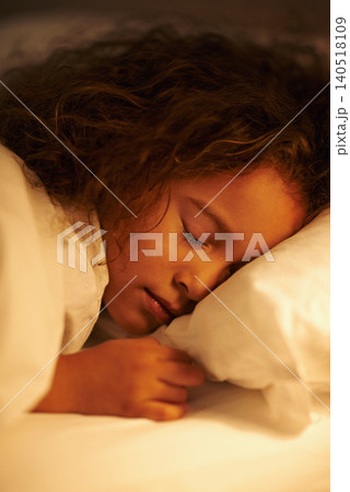 Girl, sleeping and dream in bed at night, comfortable and tired or bedtime on pillow in home. Female person, child and resting in bedroom or lying to relax, exhausted and fatigue or peace in closeup Girl, sleeping and dream in bed at night, comfortable and tired or bedtime on pillow in home. Female person, child and resting in bedroom or lying to relax, exhausted and fatigue or peace in closeup 140518109