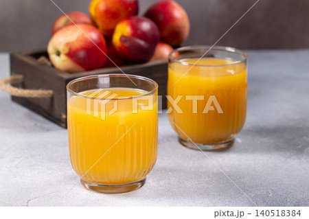 Fresh nectarine juice in glasses with ripe fruit Fresh nectarine juice in glasses with ripe fruit 140518384