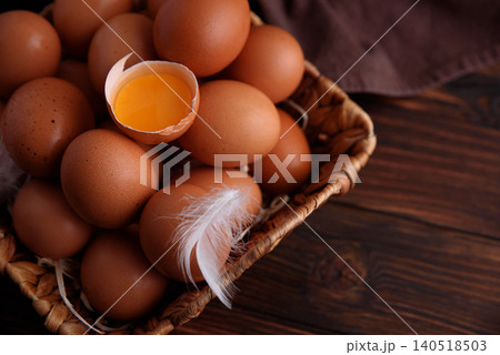 Brown eggs in basket with broken egg yolk Brown eggs in basket with broken egg yolk 140518503