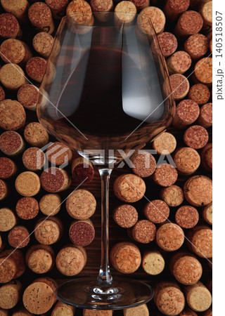 Red wine glass featuring bordeaux against cork background 140518507