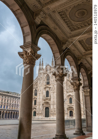 Milan, italy, october 2, 2024. Historic milan duomo cathedral, a famous gothic masterpiece, visible behind the intricate arches of the vittorio emanuele ii gallery Milan, italy, october 2, 2024. Historic milan duomo cathedral, a famous gothic masterpiece, visible behind the intricate arches of the vittorio emanuele ii gallery 140518979