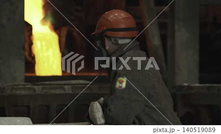 Skilled Factory Staff Member In Safety Gear Oversees Pouring Of Molten Material Near Hightemperature Furnace . Stock clip Skilled Factory Staff Member In Safety Gear Oversees Pouring Of Molten Material Near Hightemperature Furnace . Stock clip 140519089