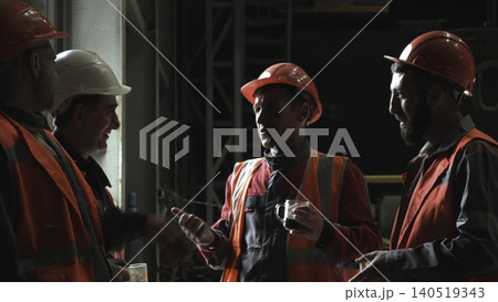 Industrial Team In Safety Gear Strategize Over Project Responsibilities Amidst Equipment And Scaffolding . Stock clip Industrial Team In Safety Gear Strategize Over Project Responsibilities Amidst Equipment And Scaffolding . Stock clip 140519343