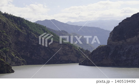 Peaceful Waterbody Enclosed By Thick Forested Ridges Under Gentle Sunlight And Calm Atmosphere. Media Peaceful Waterbody Enclosed By Thick Forested Ridges Under Gentle Sunlight And Calm Atmosphere. Media 140519490