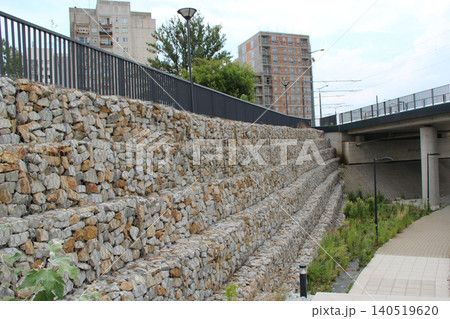 construction of gabion retaining wall as part of fencing. Gabion wall in the city construction of gabion retaining wall as part of fencing. Gabion wall in the city 140519620