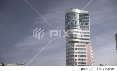 Contemporary Skyscraper With Artistic Flair. Stylish Building Featuring Curved Glass And Pastel Colors . Media 140519646