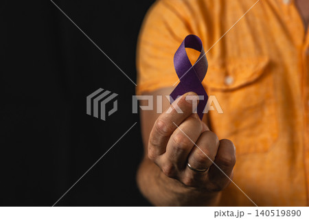 Man holds purple awareness ribbon to support health campaign 140519890