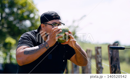 Latino man drinking fresh coconut water outdoors Latino man drinking fresh coconut water outdoors 140520542