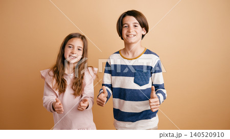Children smiling giving thumbs up in studio Children smiling giving thumbs up in studio 140520910