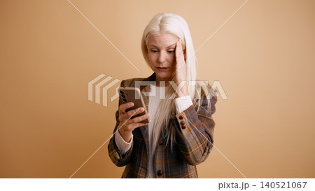 Woman receiving bad news on smartphone feeling headache and stress 140521067