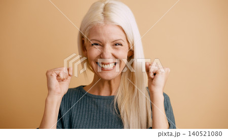Happy senior woman celebrating success with fists up Happy senior woman celebrating success with fists up 140521080