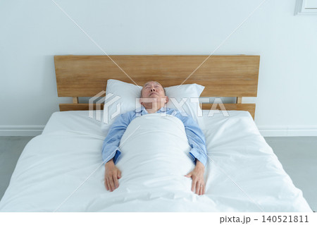 ベッドで眠る高齢者の男性 ベッドで眠る高齢者の男性 140521811