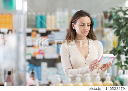 Adult woman chooses pills at pharmacy 140522479