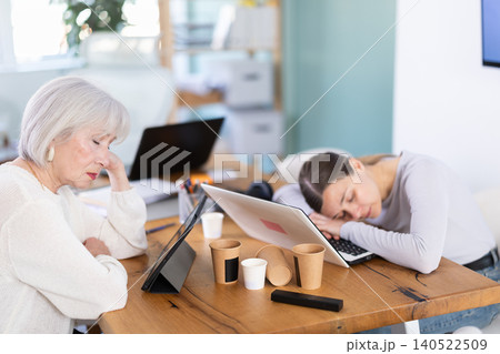 Tired businesswomens sleeping in the office with her head on table Tired businesswomens sleeping in the office with her head on table 140522509