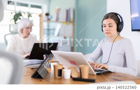 Two businesswomen work on laptops in modern company office Two businesswomen work on laptops in modern company office 140522560