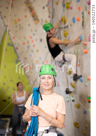Senior confident female climber with her equipment getting ready for training Senior confident female climber with her equipment getting ready for training 140522733