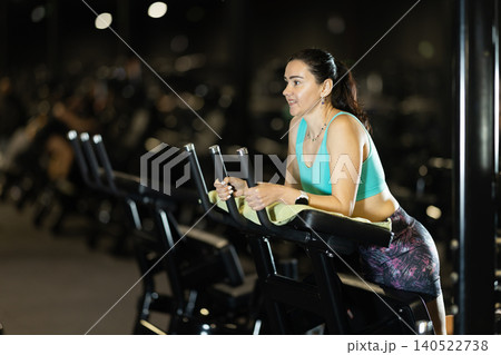 In gym, woman uses gym apparatus to strengthen leg muscles 140522738