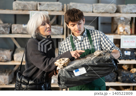 Older woman choosing mycelium in a garden store 140522809