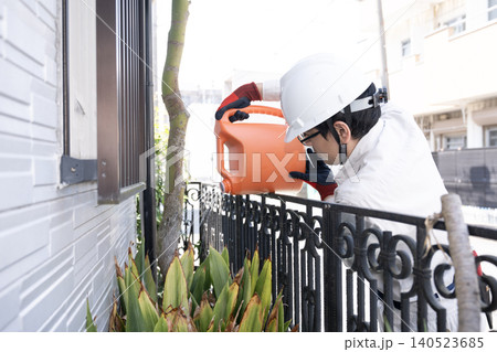 個人宅の敷地内に除草剤をまく作業員 個人宅の敷地内に除草剤をまく作業員 140523685