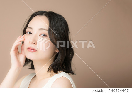 茶色背景でアンニュイな表情で見つめる女性の美容やビューティーポートレート カメラ目線で肌が気になる 茶色背景でアンニュイな表情で見つめる女性の美容やビューティーポートレート カメラ目線で肌が気になる 140524467