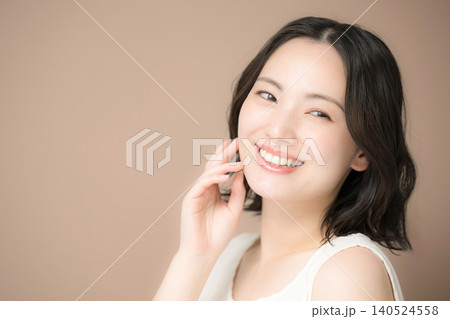 茶色背景で自然な笑顔の女性の秋のカメラ目線美容とビューティーポートレート 茶色背景で自然な笑顔の女性の秋のカメラ目線美容とビューティーポートレート 140524558