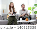 Father and daughter playing video games together at home. Happy family spending quality time, bonding, entertainment, and modern lifestyle in a cozy living room. 140525339