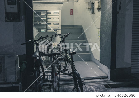 夜のレトロな集合住宅入口　自転車と共用階段 140526980