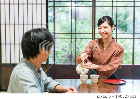 温泉旅館の客室でお茶を淹れる旅館スタッフ・仲居さんの女性 温泉旅館の客室でお茶を淹れる旅館スタッフ・仲居さんの女性 140527619