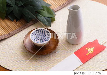 榊と日本酒、徳利を並べた祝いと神事の静物写真|寿の箸袋が添えられた和の儀式イメージ 榊と日本酒、徳利を並べた祝いと神事の静物写真|寿の箸袋が添えられた和の儀式イメージ 140527698