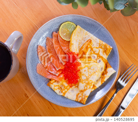 Thin pancakes with caviar and salmon on a plate Thin pancakes with caviar and salmon on a plate 140528695
