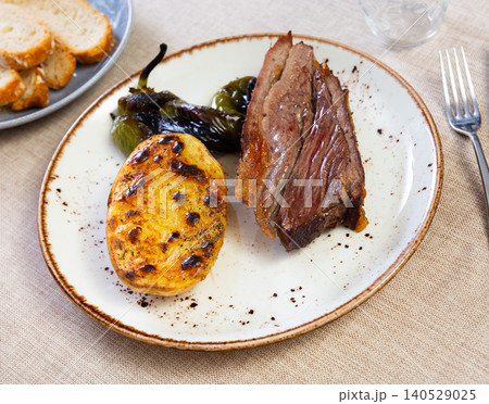 Hot dinner of spiced roast beef with fried potatoes and peppers on white plate. Hot dinner of spiced roast beef with fried potatoes and peppers on white plate. 140529025