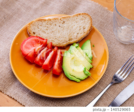 Sliced avocado and tomato on a plate top view 140529065