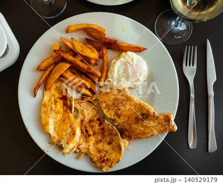 Fried chicken breast with potatoes and fried egg 140529179