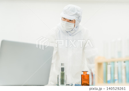 薬品工場,製薬会社で薬品開発をするクリーンスーツを着たスタッフ 140529261
