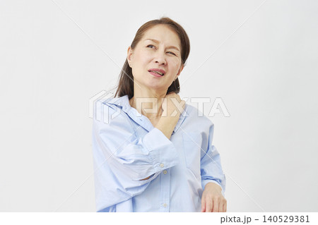 白背景で肩の痛みに悩む女性 白背景で肩の痛みに悩む女性 140529381