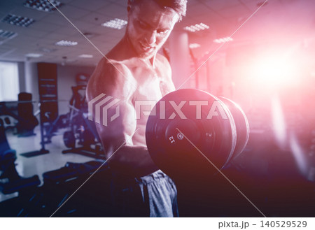 Handsome muscular man working out with dumbbells. 140529529