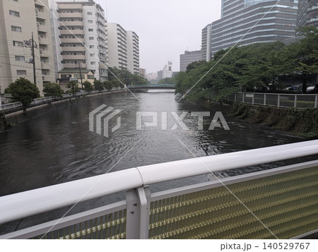 大雨によって危険水域まで増水する河川 140529767