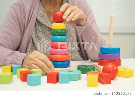 Alzheimer disease AD, Asian elderly woman patient suffering from dementia learn practical motor skills rehabilitation. Alzheimer disease AD, Asian elderly woman patient suffering from dementia learn practical motor skills rehabilitation. 140530175