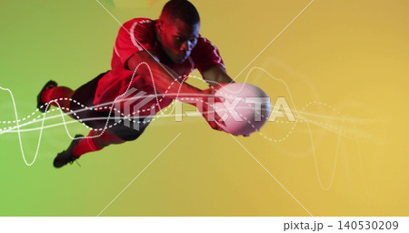 Diving athlete reaching to catch white ball in studio gradient, red jersey, black shorts, overlays Diving athlete reaching to catch white ball in studio gradient, red jersey, black shorts, overlays 140530209