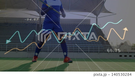 Standing athlete in knee-high blue socks and red cleats holding stick on turf with cyan-orange data Standing athlete in knee-high blue socks and red cleats holding stick on turf with cyan-orange data 140530284