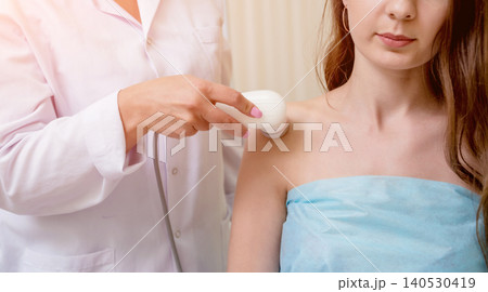 Ultrasound treatment in physical therapy. Doctor using an ultrasound machine to treat the joints and muscles of a patient 140530419