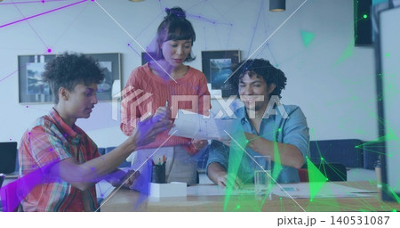 Reviewing small team at wooden table in office, woman in coral sweater holding papers, overlay 140531087