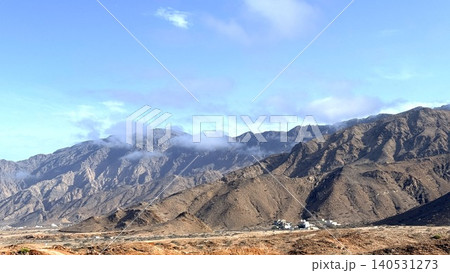 Arid Mountain Range with Sparse Settlement under Blue Sky Arid Mountain Range with Sparse Settlement under Blue Sky 140531273