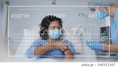 Reclining patient wearing surgical mask, gown receiving care in bay 2, nurse leaning in blue scrubs Reclining patient wearing surgical mask, gown receiving care in bay 2, nurse leaning in blue scrubs 140531347